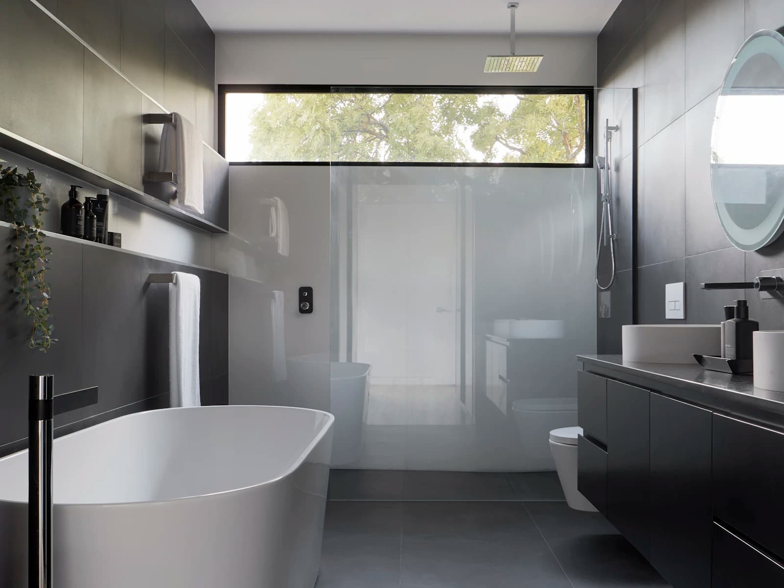 Contemporary bathroom with a round mirror and wall-hung vanity