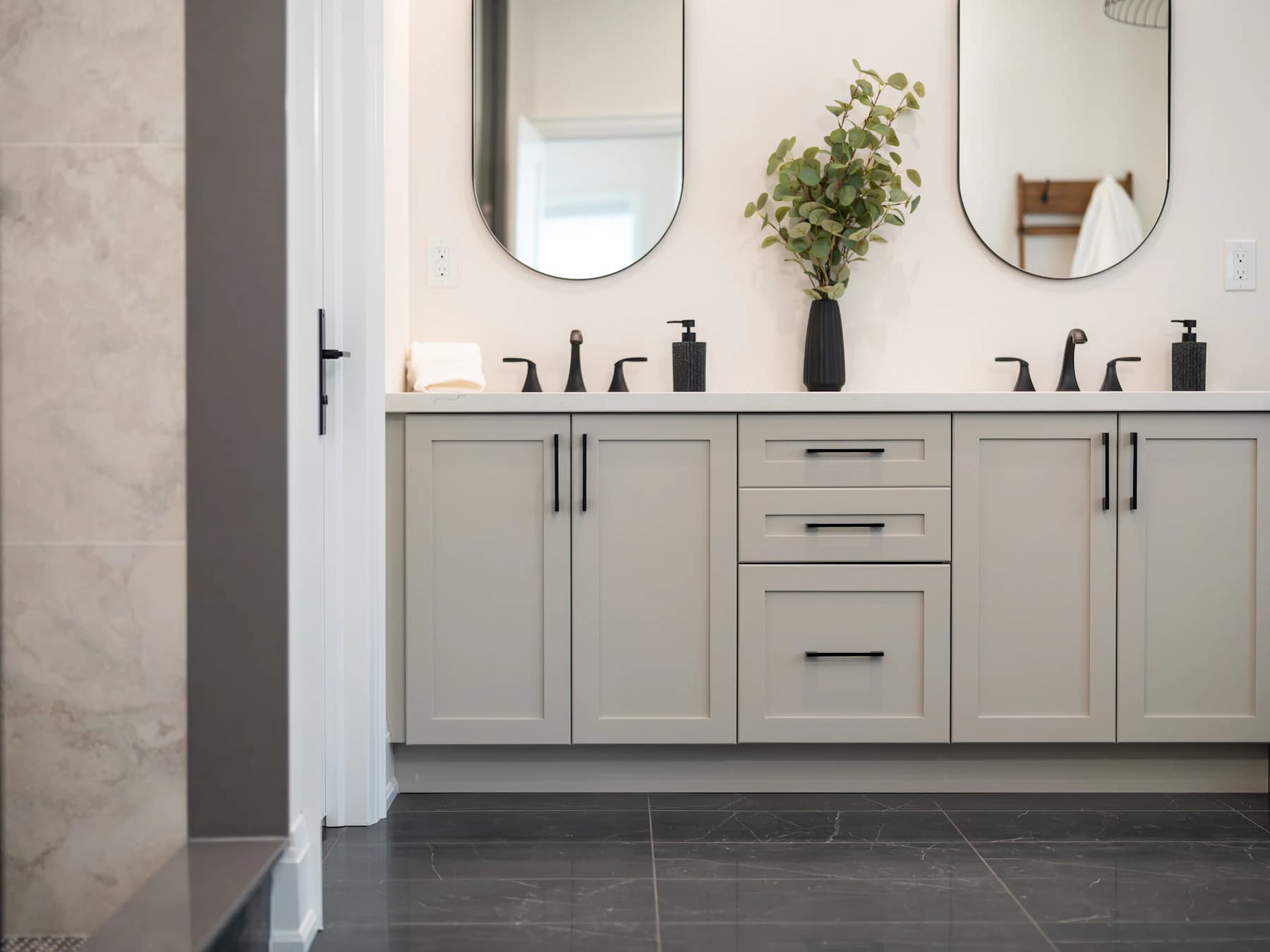 Painted double vanity with oval mirrors and black brassware