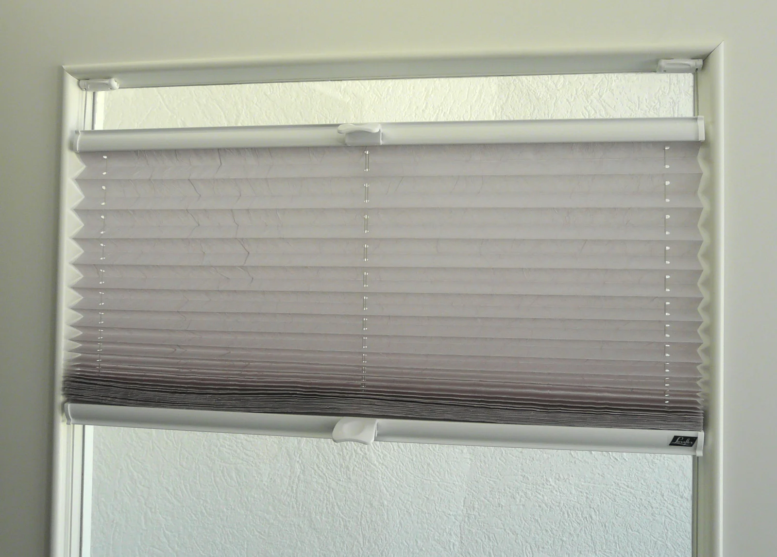 White plissé blind with accordion pleats fitted in a window