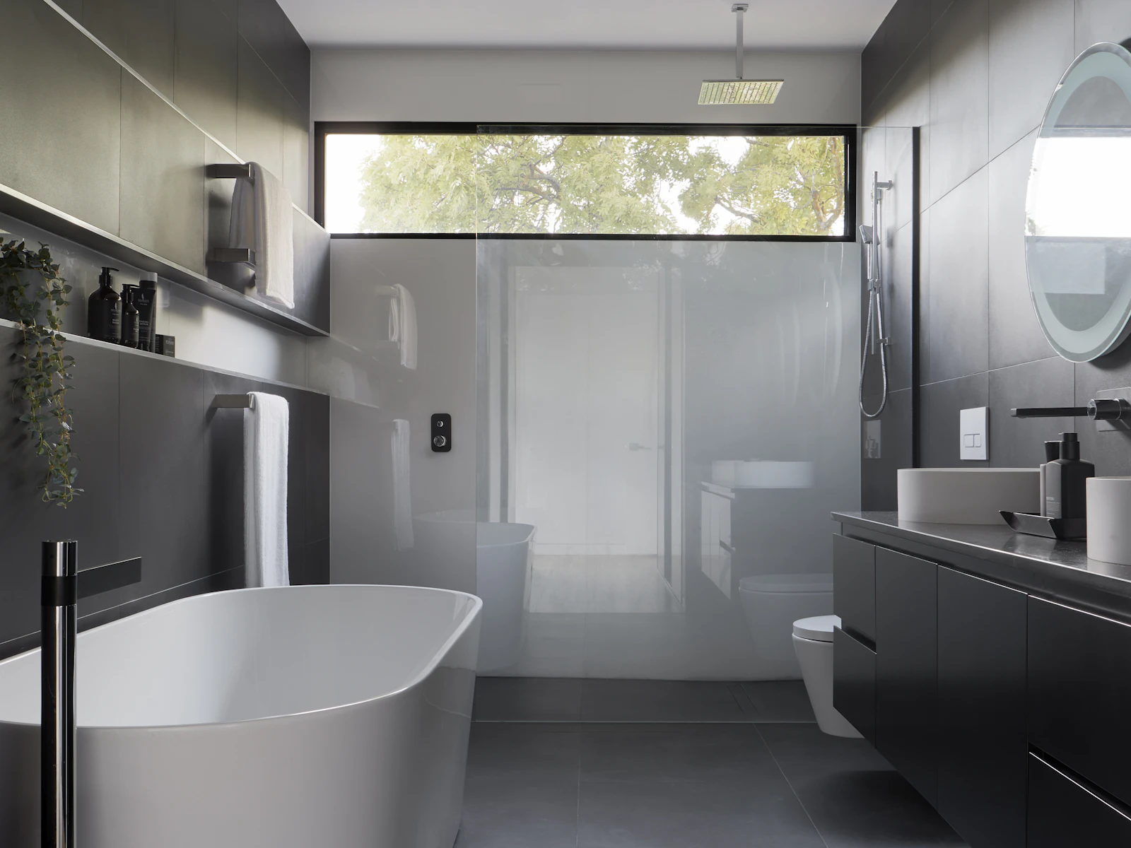 Contemporary bathroom with a round mirror and wall-hung vanity