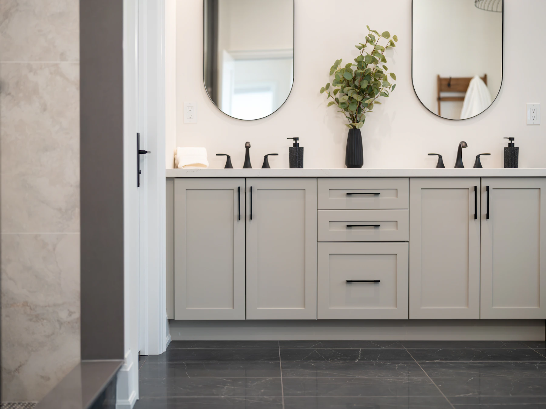 Painted double vanity with oval mirrors and black brassware