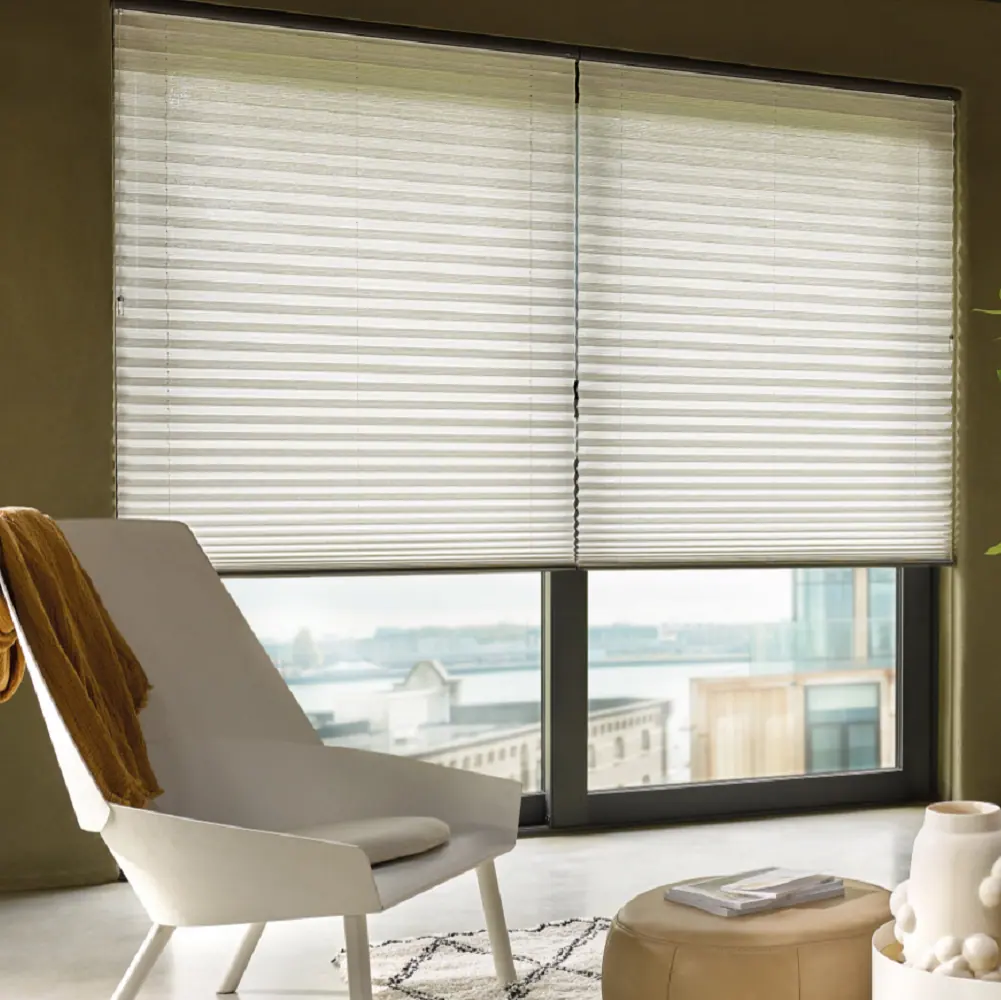 Cream plissé blinds filtering daylight over a waterfront window