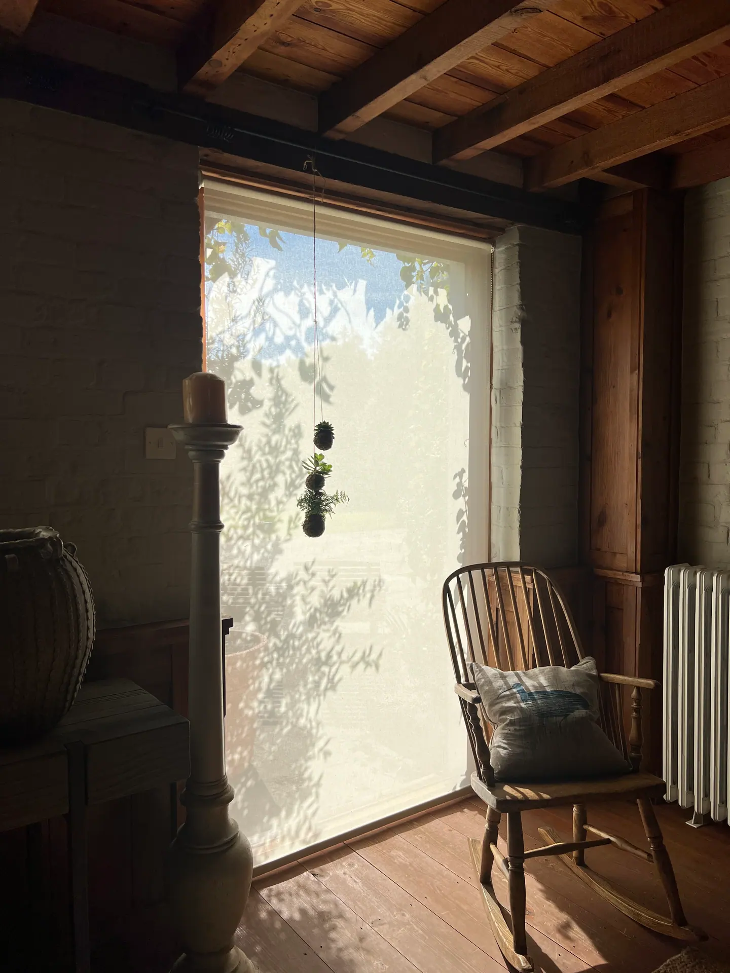Cream light-filtering roller blind in a beamed room