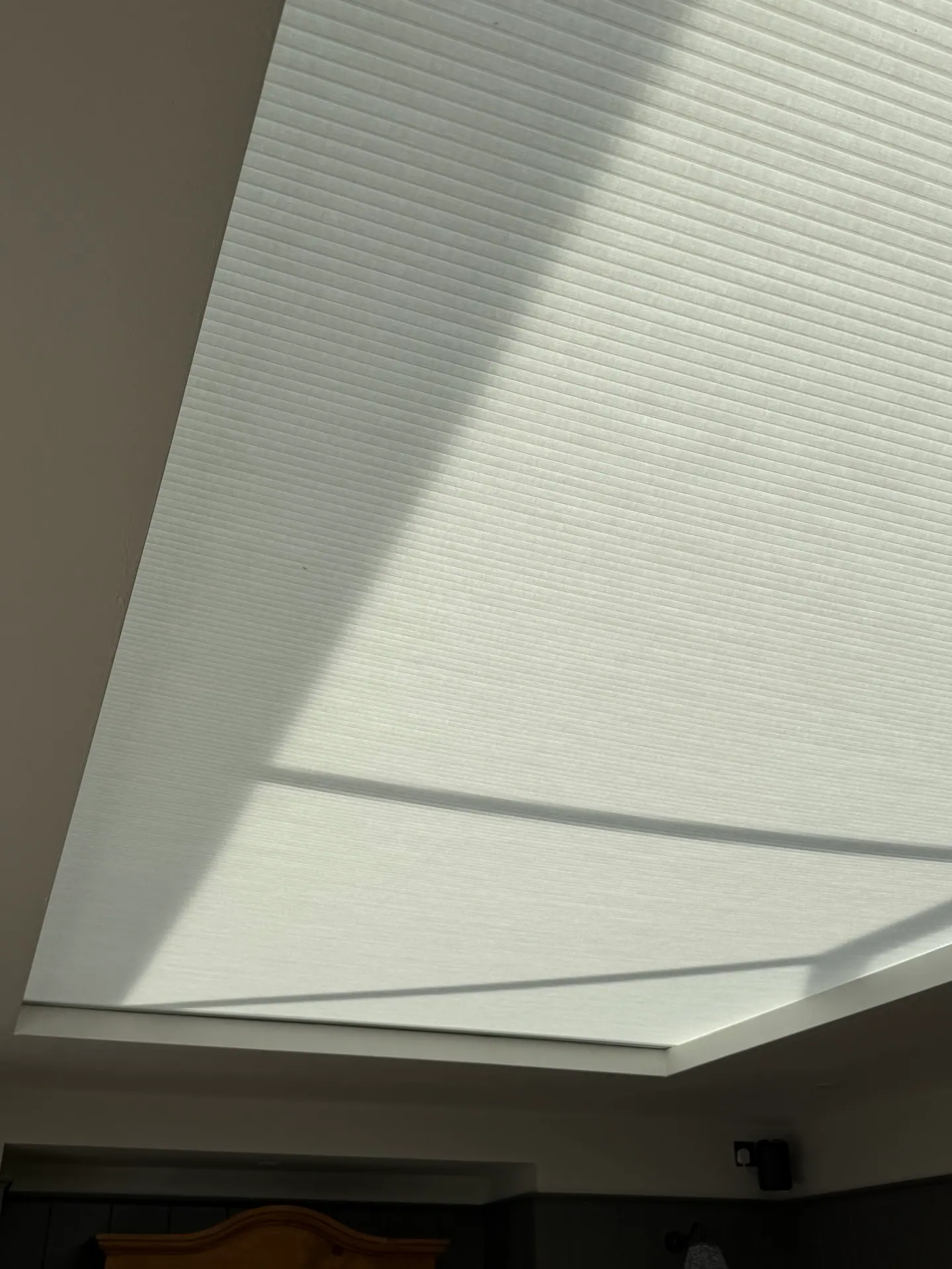 Off-white pleated lantern blind with sunlight and shadow across the pleats