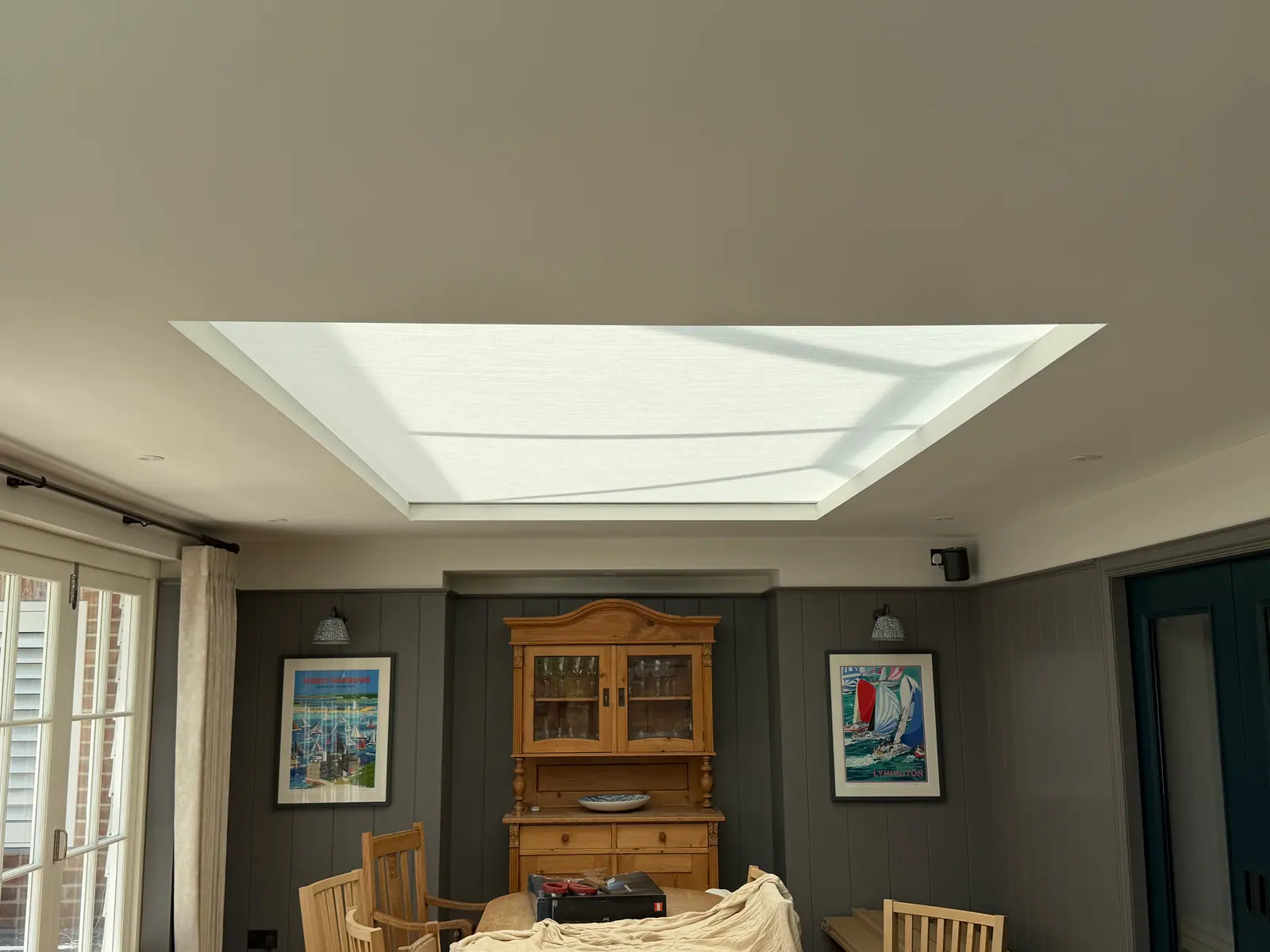 White pleated lantern blind covering a large recessed skylight above a dining room
