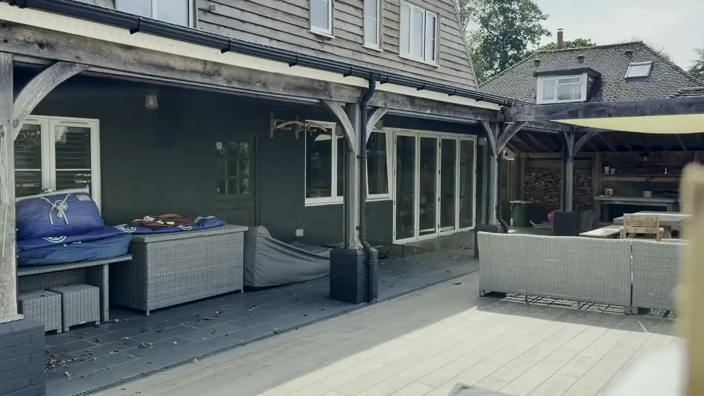 Luxaflex external screen blinds retracted under a timber veranda, showing discreet head boxes across three openings