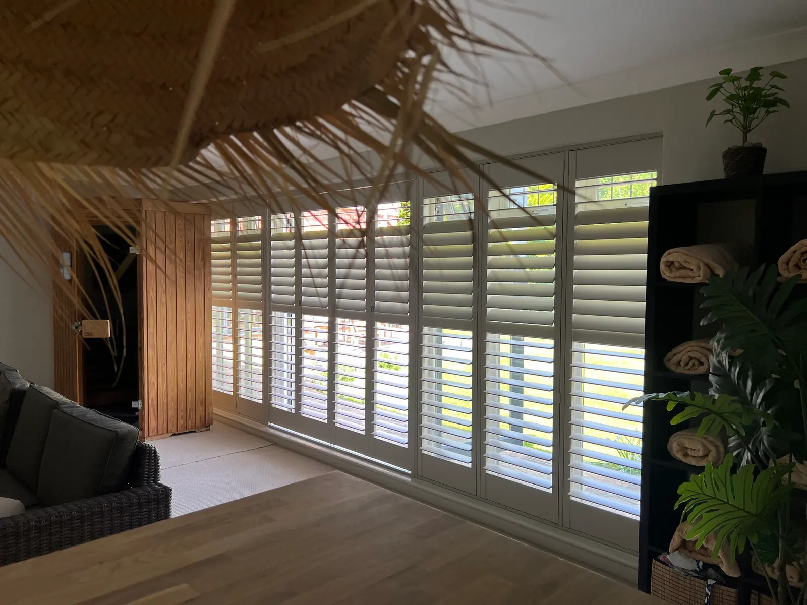 Full-height white S:CRAFT shutters with open louvres in a furnished living space, Crestwood of Lymington