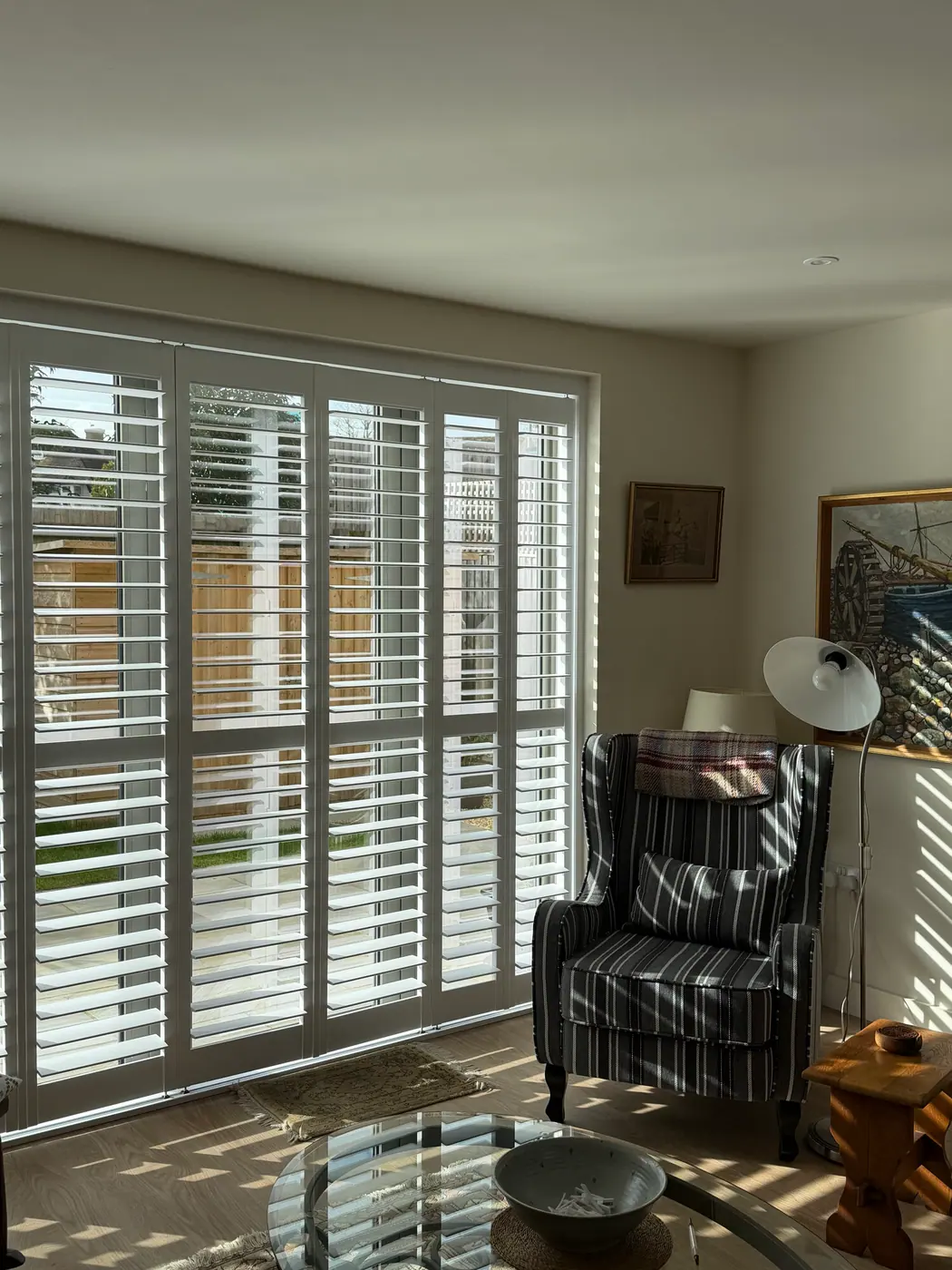 Full-height white S:CRAFT shutters on patio doors with louvres tilted open, fitted by Crestwood of Lymington